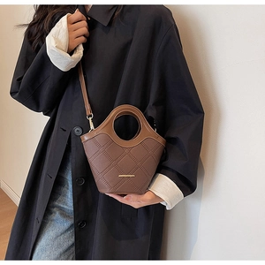 Détail du sac à main en cuir marron café avec texture litchi et motif en losanges
