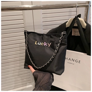 Detail der schwarzen Nylon-Beuteltasche mit Lucky-Stickerei und Kettenriemen