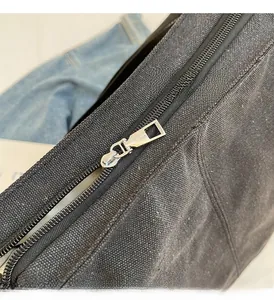 Gros plan du sac en toile noire avec fermeture éclair en métal argenté et coutures nettes