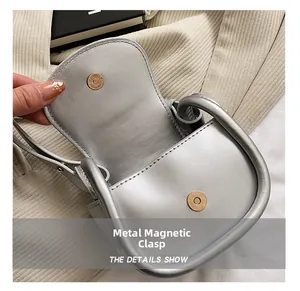 Close-up of magnetic buckle detail on silver mini heart-shaped crossbody bag