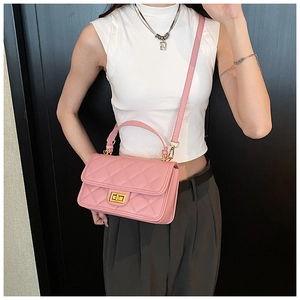 Modello con borsa a tracolla trapuntata rosa con chiusura a scatto dorata e manico chic