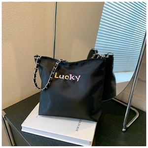 Detail der schwarzen Nylon-Beuteltasche mit Lucky-Schriftzug und Metallkettenriemen