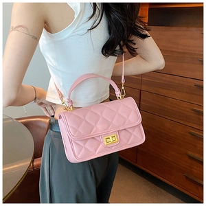Dettaglio di borsa rosa trapuntata con chiusura a rotazione dorata e tracolla a catena