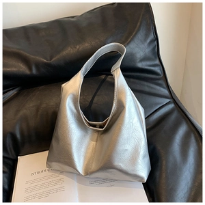 Détail du sac hobo argenté métallisé avec texture froissée sur fond noir élégant