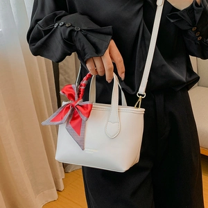 Chic white leather bucket bag with silk scarf accent and crossbody strap for women