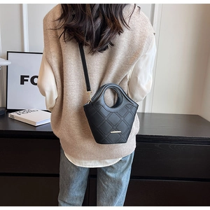 Détails du sac seau noir en cuir litchi avec motifs en losange et finitions métalliques dorées