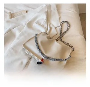 Detail showing creamy white pleated leather bag texture and silver woven metal chain strap