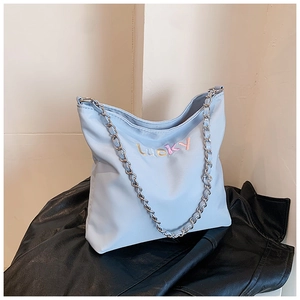 Detail der hellblauen Oxford-Beuteltasche mit bunter Lucky-Stickerei und Kettenriemen