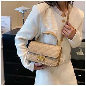 Dettaglio della mini borsa a tracolla trapuntata beige con chiusura dorata e texture in pelle