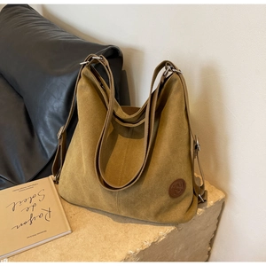 Vue détaillée du sac cabas en toile kaki avec son écusson logo en cuir haut de gamme