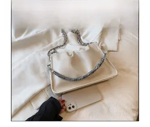 Size comparison of a cream-colored pleated cloud bag with a smartphone and silver chain