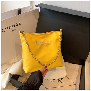 Detailansicht der gelben Oxford-Stoffbeuteltasche mit Lucky-Stickerei und Goldkette