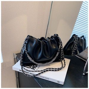 Detail of soft black pleated cloud bag with silver chain strap and metallic hardware