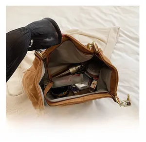 Top view of large brown suede tote bag showing spacious interior with cosmetics and gold buckle
