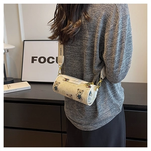 Détail du sac cylindrique avec imprimé ours et large bandoulière à logo sur le modèle