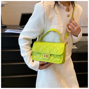 Borsa a mano trapuntata verde lime in pelle PU con chiusura dorata sulla scrivania