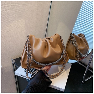 Detail of camel cloud bag with pleated leather texture and decorative silver chain strap