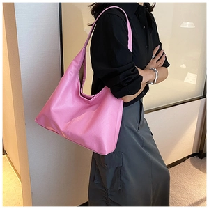 Détail latéral du grand sac hobo en cuir rose porté par un mannequin pour le quotidien