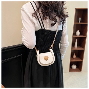 Detailed back view of a white heart-shaped mini saddle bag with brown shoulder strap