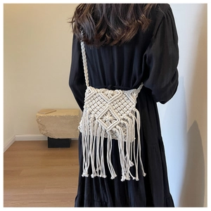Detail einer Boho-Makramee-Umhängetasche mit handgewebten Mustern und langen Baumwollfransen