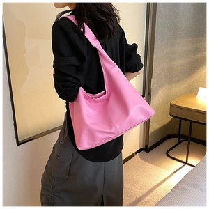 Grand sac hobo rose vif porté par un mannequin dans un décor intérieur contemporain