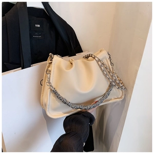 Detail of creamy off-white cloud bag with silver metal chain and soft pleated texture