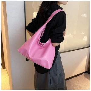 Vue latérale d'un grand sac hobo en cuir PU rose porté sur une tenue noire