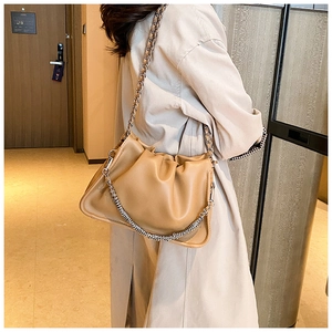 Detail view of khaki cloud bag with ruched texture and chunky gold chain strap
