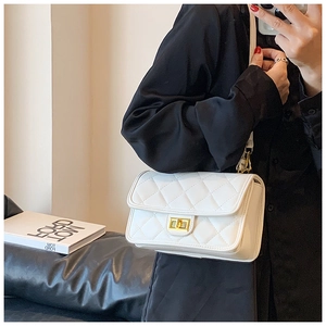 Dettaglio di una borsa a tracolla bianca trapuntata con chiusura a scatto dorata