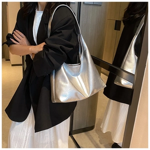 Détail d'un sac cabas argenté métallisé avec texture plissée porté par un mannequin