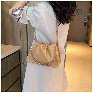 Detail of khaki pleated cloud bag featuring textured silver thick metal chain strap