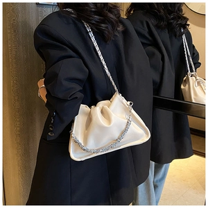Detail of off-white cloud pleat handbag featuring dual silver metallic chain straps