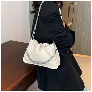Detail of creamy white cloud bag with silver chain strap and twisted metal handle