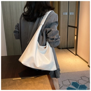 Sac cabas blanc minimaliste porté par un mannequin en tenue de bureau chic