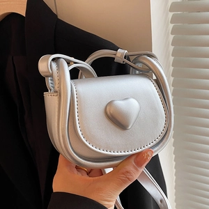 French minimalist silver metallic mini saddle bag with heart relief for women