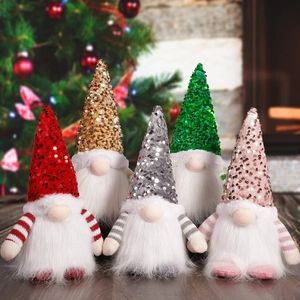 Five assorted sequined Christmas gnomes with white beards on a cozy wooden surface