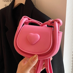 Mini hot pink PU leather saddle bag featuring a heart ornament and slim shoulder strap