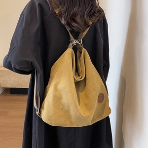 Sac à dos minimaliste en toile jaune moutarde pour femme présenté dans un cadre décontracté