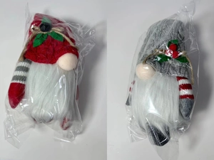 Detail of red and grey Christmas gnome plushies with knitted hats and holly leaves
