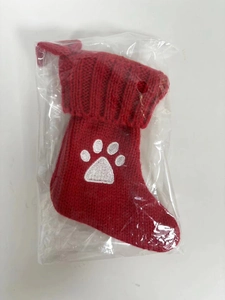 Dettaglio calzino rosso in maglia con ricamo a zampa di gatto bianca