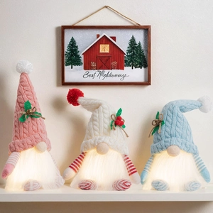 Three glowing Christmas gnomes in pink, white, and blue with LED warm light and knit hats