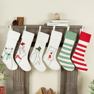 Set van 6 kerstsokken met dierenprints en strepen hangend aan een open haard