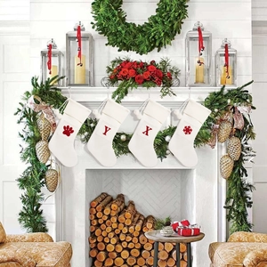 Close-up of knit Christmas stockings with red sequins on a decorated fireplace