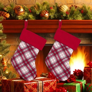 Calze di Natale a quadri rossi e neri appese alla decorazione del caminetto
