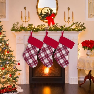 Set di tre calze di Natale a quadri appese a un caminetto in stile festivo