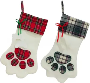Detail of dog paw shaped Christmas stockings with red and green plaid patterns and bows