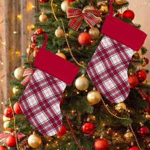 Calze di Natale scozzesi rosse con bordo in pile appese all'albero festivo