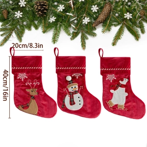 Three red velvet Christmas stockings with reindeer snowmen and bear designs on white background
