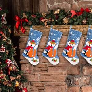 Blue plush Christmas stockings with fox motif hanging on a festive fireplace mantel
