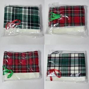 Detail of four plaid Christmas stockings with white faux fur trim in clear packaging